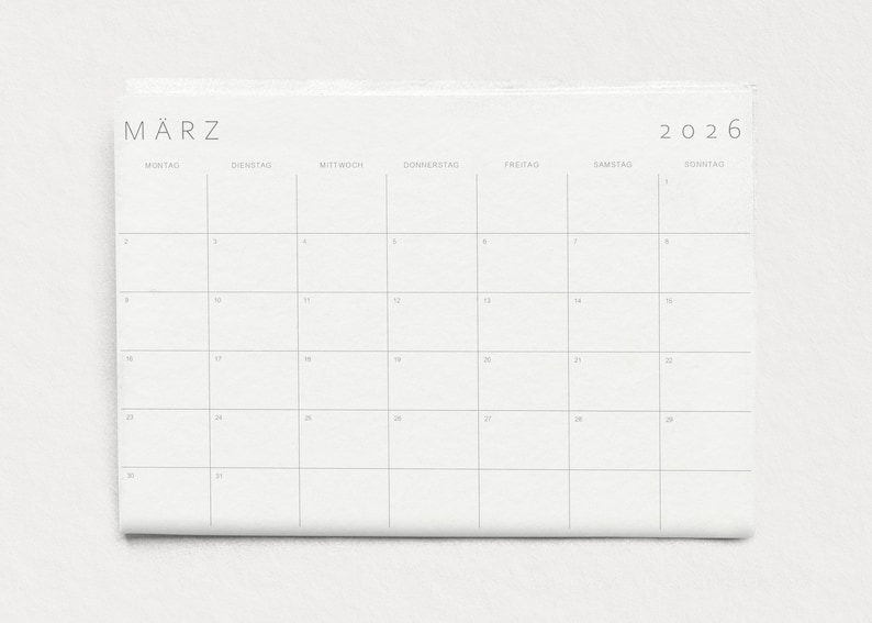 Nahaufnahme einer einzelnen Kalenderseite 2026 in A3 Querformat mit minimalistischen grauen Linien und klarer Typografie auf weißem Papier vor neutralem Hintergrund.