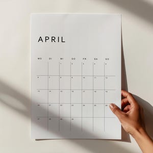 Deutscher Kalender 2026 druckbar, ein Monatsblatt auf weißem Papier im Hochformat, minimalistisches Layout mit klarer Typografie, liegt auf heller Oberfläche.