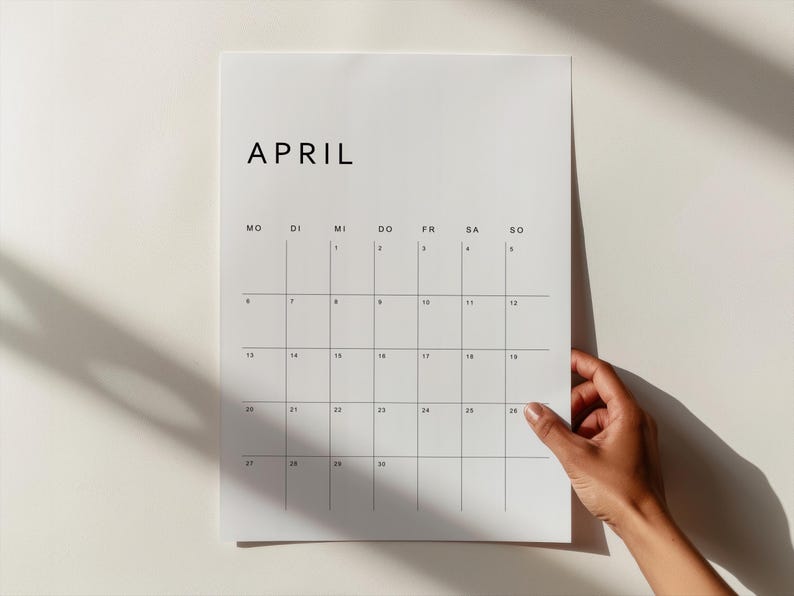 Deutscher Kalender 2026 druckbar, ein Monatsblatt auf weißem Papier im Hochformat, minimalistisches Layout mit klarer Typografie, liegt auf heller Oberfläche.