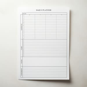 Puede incluir: Un bloc de notas blanco de Daily Planner con texto y l&iacute;neas negras. La parte superior del bloc de notas dice "DAILY PLANNER". El bloc de notas est&aacute; dividido en secciones para la fecha, el horario, las tareas, las notas y el ma&ntilde;ana.