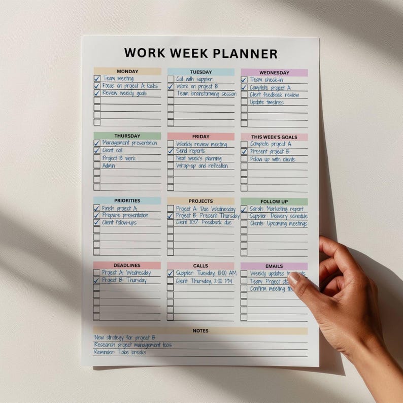 Brightly colored work week planner displaying daily sections, goals, and priorities, set against a neutral backdrop.