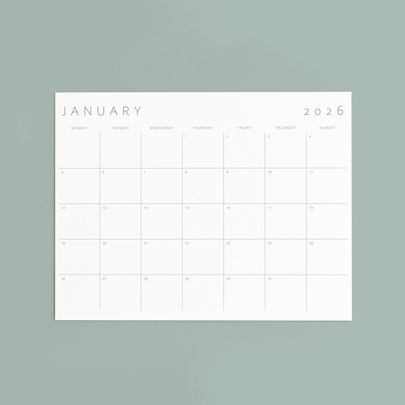 A 2026 calendar month with minimalist grey text and lines on white Letter paper, placed against a neutral medium light background, featuring landscape orientation.