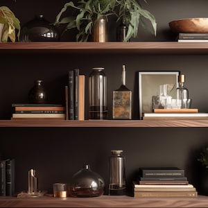 Może przedstawiać: Drewniana półka w ciemnym kolorze z dwoma półkami, wypełniona różnymi przedmiotami dekoracyjnymi, w tym książkami, wazami, roślinami i misą. Półki znajdują się na tle ciemnej ściany.