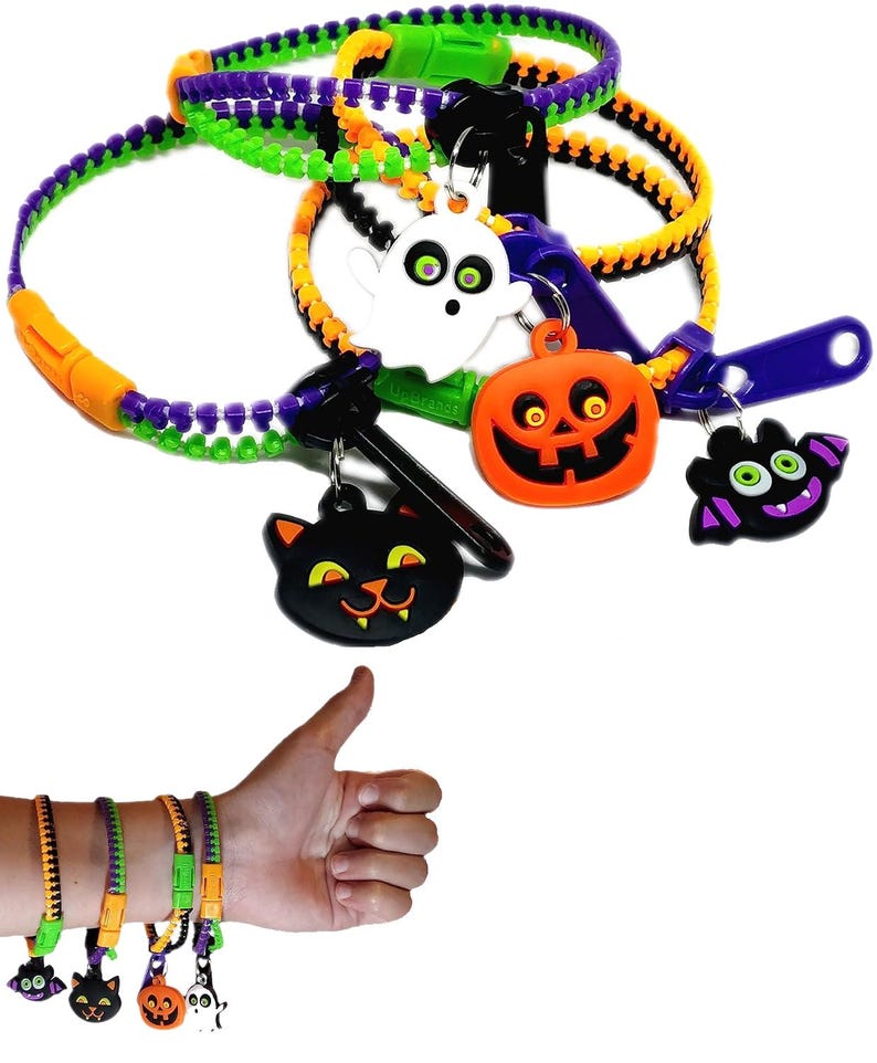 Puede incluir: Conjunto de cuatro pulseras de cremallera de Halloween con abalorios. Cada pulsera est&aacute; hecha de cinta de cremallera naranja, verde y morada. Los abalorios son un fantasma, una calabaza, un murci&eacute;lago y un gato negro.