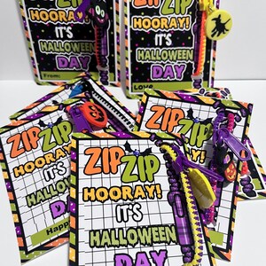 Puede incluir: Cuatro pulseras de cremallera de colores con tem&aacute;tica de Halloween con una etiqueta que dice "Zip Zip &iexcl;Hurra! &iexcl;Es Halloween!" y "Feliz Halloween".