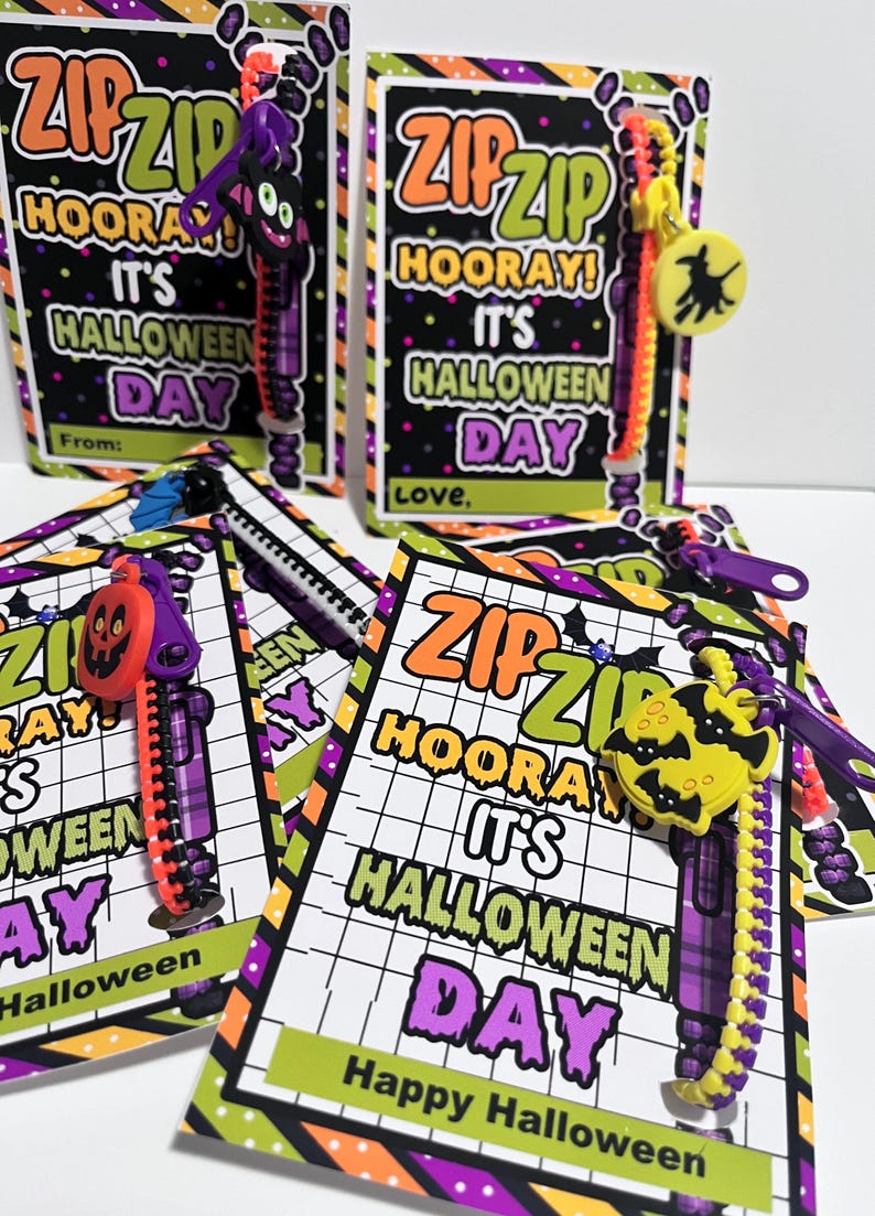 Puede incluir: Cuatro etiquetas de regalo con tem&aacute;tica de Halloween con tiradores de cremallera adjuntos. Las etiquetas son negras con rayas moradas, verdes y naranjas. El texto en las etiquetas dice "Zip Zip Hooray! It's Halloween Day".