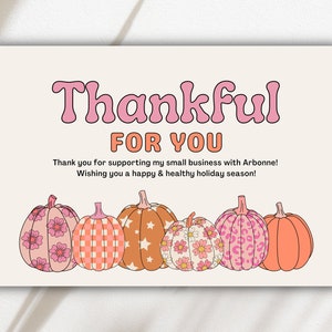 May include: A thank you card with the text "Thankful for you" in pink letters. The card features a row of six pumpkins with different patterns, including floral, checkered, and star patterns. The pumpkins are in shades of pink, orange, and brown.
