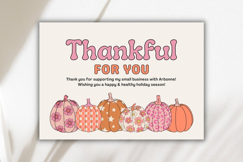 May include: A thank you card with the text "Thankful for you" in pink letters. The card features a row of six pumpkins with different patterns, including floral, checkered, and star patterns. The pumpkins are in shades of pink, orange, and brown.