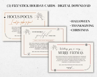 May include: Three printable holiday cards featuring a festive design with the text "Hocus Pocus I need fizz sticks to focus!"  "So incredibly grateful for you" and "Wishing you a very Merry Fizzmas". The cards are decorated with a red and white snowflake, a leaf, and a pair of champagne glasses.