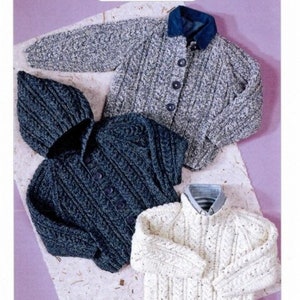 May include: Three Aran-style knitted sweaters are shown. One is a grey button-up cardigan with a blue collar. Another is a dark blue hooded cardigan. The third is a white sweater with a striped pattern. The image also includes the text "Aran Knitting".