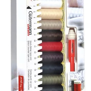 May include: A Gütermann Creativ sewing thread set with various thread colours. The set includes a stitch counter and a red thread holder. The packaging is white with red accents and features the text "Gütermann Creativ".