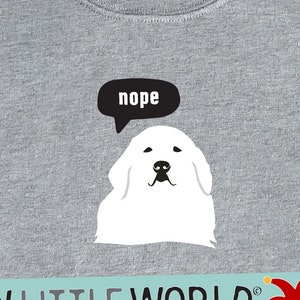 May include: Gray sweatshirt with a white dog and a speech bubble that says "nope". The text "SILLY LITTLE WORLD" is printed on a blue and yellow banner with a red jester's hat.
