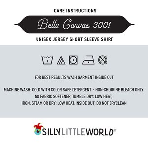 May include: Care instructions for a Bella Canvas 3001 unisex jersey short sleeve shirt. The instructions include machine wash, tumble dry, and iron settings. The instructions also state to wash the garment inside out and to use color safe detergent.