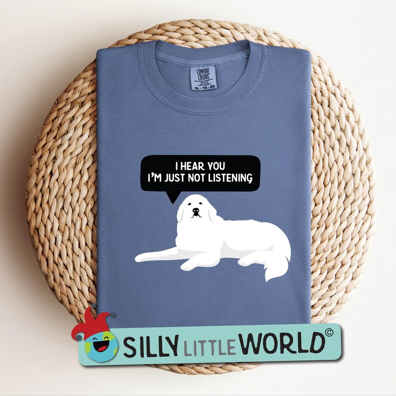 K&ouml;nnte beinhalten: Ein blaues T-Shirt mit einer Illustration eines wei&szlig;en Pyren&auml;enberghundes und dem Text "Ich h&ouml;re dich, aber ich h&ouml;re nicht zu".