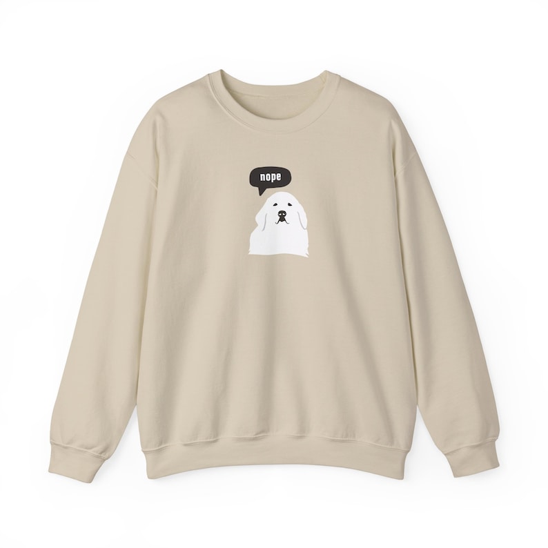 May include: A beige sweatshirt with a white dog wearing a speech bubble that says "nope".