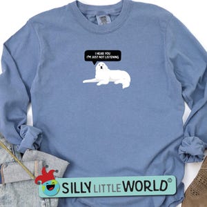 K&ouml;nnte beinhalten: Ein blaues Langarmshirt mit einer Illustration eines wei&szlig;en Pyren&auml;enberghundes und dem Text "I hear you I'm just not listening".