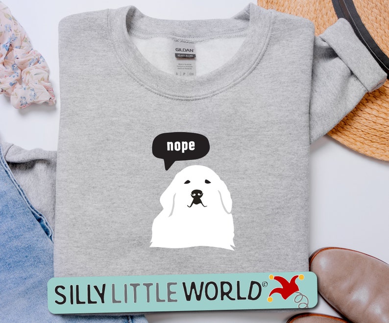 May include: Gray sweatshirt with a white dog illustration and a speech bubble that says "nope". The sweatshirt has the text "SILLY LITTLE WORLD" with a red jester hat graphic.