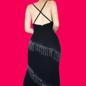 May include: A black spaghetti strap dress with a silver sequined fringe detail.