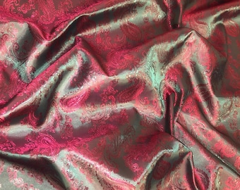 May include: Close-up of a fabric with a paisley pattern in shades of teal and pink.
