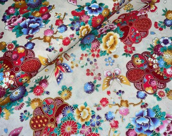 Könnte beinhalten: Cremefarbener Stoff mit einem sich wiederholenden Muster aus roten, goldenen und blauen Blumen, Schmetterlingen und geometrischen Formen. Der Stoff hat einen dezenten Schimmer.