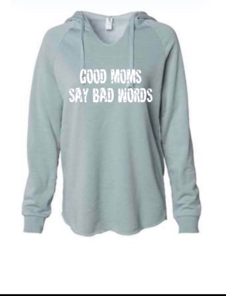 Op de afbeelding: Een lichtblauw hoodie met de tekst "GOOD MOMS SAY BAD WORDS" in wit gedrukt.