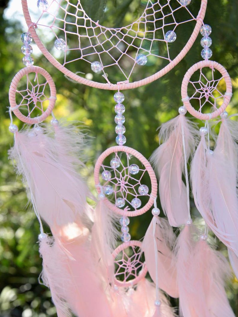 Pretty Pink coloured dream catcher with 5 circles decorated with beads and large hanging pink feathers.
