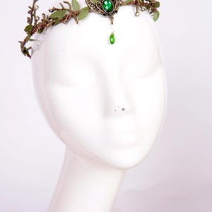Fairy crown, elven tiara, green foliage, the centre is decorated with a metal crescent moon and green hanging crystal. Adjustable at back with a ribbon tie.