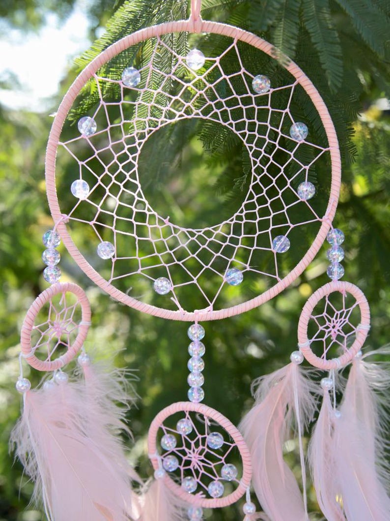 Pretty Pink coloured dream catcher with 5 circles decorated with beads and large hanging pink feathers.