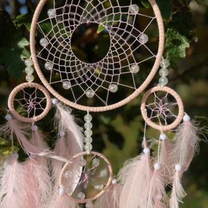 Pretty Pink coloured dream catcher with 5 circles decorated with beads and large hanging pink feathers.