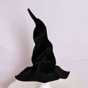 May include: A black witch hat with a tall, pointed crown and a wide, floppy brim. The hat is made of a soft, velvety material. This Halloween costume accessory is perfect for trick-or-treating or themed parties.