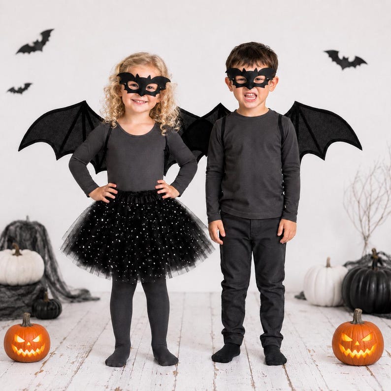 May include: A black bat costume set, comprising wings, a mask, and a tutu skirt. The wings feature red detailing, and the skirt is adorned with white star-shaped sparkles. The costume is designed for children.