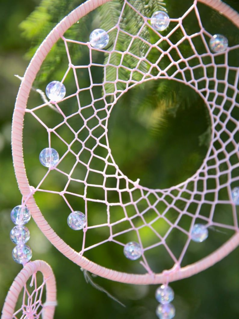 Pretty Pink coloured dream catcher with 5 circles decorated with beads and large hanging pink feathers.