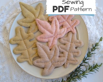 May include: A set of five fabric leaf shapes in various shades of brown and pink. The leaves are stitched with a decorative pattern and are arranged on a white plate. The text "Sewing PDF Pattern" is visible in the top right corner of the image.