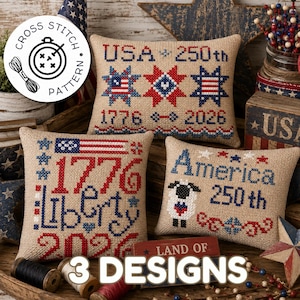 Può includere: Tre cuscini rettangolari in tela di juta color marrone chiaro con disegni patriottici a punto croce. Il cuscino superiore mostra USA 250th, 1776-2026 e stelle. Quello in basso a sinistra mostra 1776 Liberty 2026. Quello a destra una pecora e America 250th.