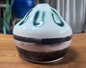 Mid-century style ceramic vase features a cream-colored glaze with decorative green and dark brown markings
