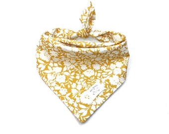 May include: A yellow bandana with a white floral pattern and a small white label that says "Hey, Frenchie" with a paw print logo.