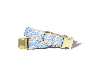 Könnte beinhalten: Ein hellblaues Hundehalsband mit einem weißen Paisley-Muster und goldenen Beschlägen.
