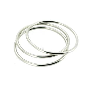 Könnte beinhalten: Drei silberne Ringe, die übereinander gestapelt sind. Die Ringe sind alle gleich groß und gleich geformt und aus einem glatten, glänzenden Metall gefertigt.