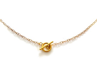 May include: A gold chain necklace with a toggle clasp.