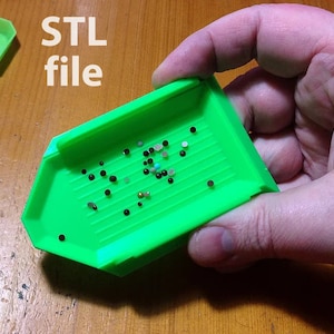 May include: Green plastic tray with a grid pattern and a small amount of colourful beads inside. The tray is labelled "STL file".