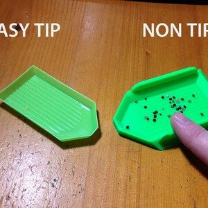 May include: Two green diamond painting trays, one labeled "EASY TIP" and the other labeled "NON TIP". The tray labeled "EASY TIP" is empty, while the tray labeled "NON TIP" is filled with small black and white diamonds.