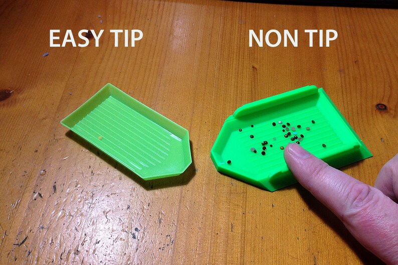 May include: Two green diamond painting trays, one labeled "EASY TIP" and the other labeled "NON TIP". The tray labeled "EASY TIP" is empty, while the tray labeled "NON TIP" is filled with small black and white diamonds.