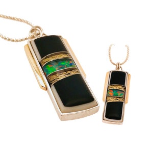 May include: Two silver and gold necklaces with black onyx and opal pendants. The larger pendant has a white border and three gold bands with opal inlay.