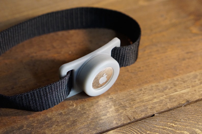 May include: A gray Apple Watch band with a black strap and a silver buckle.