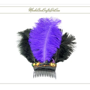 May include: Purple and black feather hair comb with Halloween themed decorations. The comb has a black base with a gold trim and features a pumpkin, a witch's hat, and other Halloween-themed embellishments. The comb is adorned with a large purple feather and smaller black feathers.