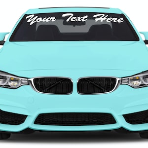 May include: A light blue car with a black grill and the text "Your Text Here" in white across the top of the windshield. The car has a sleek, modern design.