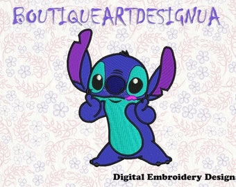 May include: Blue, turquoise, and purple cartoon character with large eyes and a pink mouth. The character is making a peace sign with both hands. The background is a white fabric with a floral pattern.