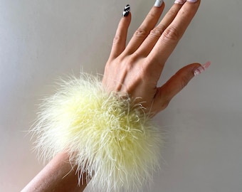 Braccialetti in piume di marabù gialle: soffici bracciali in pelliccia per feste glamour e matrimoni.