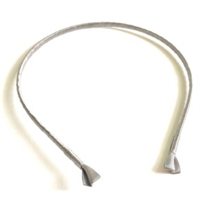 May include: A silver headband with a simple design. The headband is made of a soft, flexible material and is perfect for everyday wear.