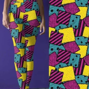 Könnte beinhalten: Gelbe, rosa, blaue und schwarze gemusterte Leggings mit Patchwork-Design. Die Leggings haben ein genähtes Nahtdetail.